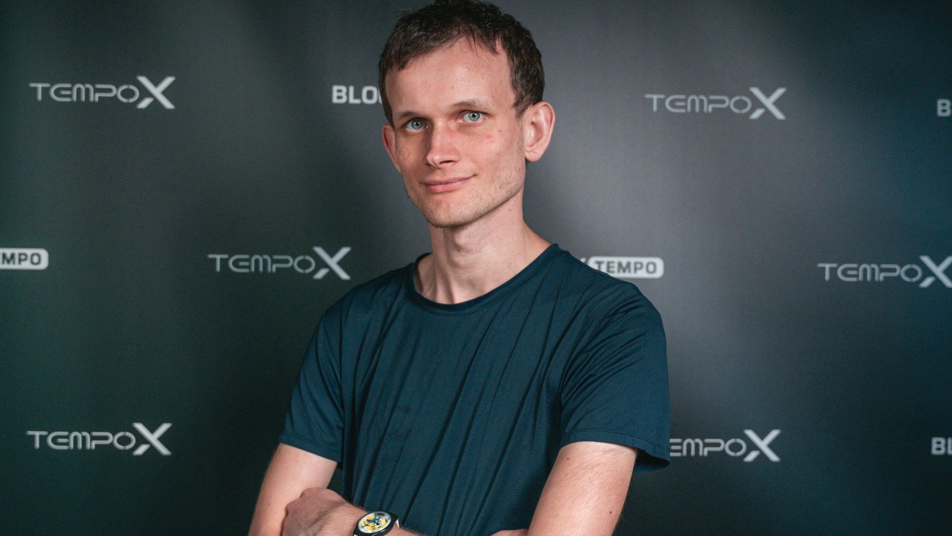 Vitalik les bras croisés et souriant